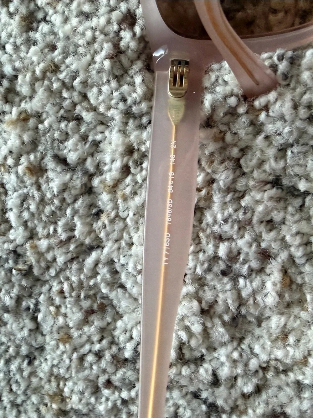 Tory Burch Pale Pink Frame Sunglasses with cat eye shape with gold detail.